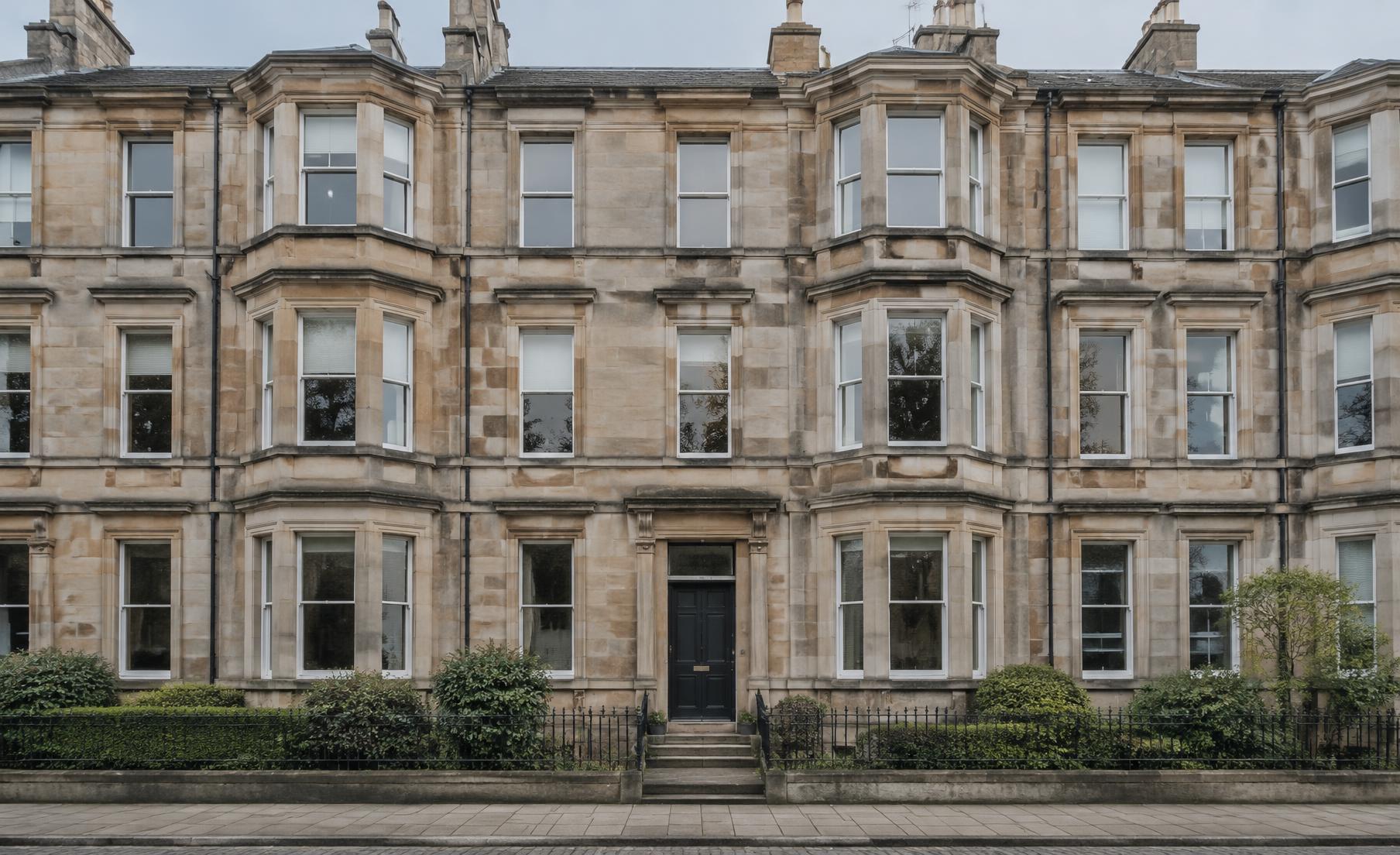 Restored sandstone tenement facade with clean stone and crisp lime joints